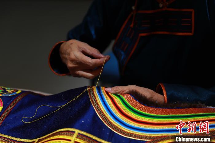 图为娜仁其其格正在手工缝制传统蒙古族服饰　陈坤　摄