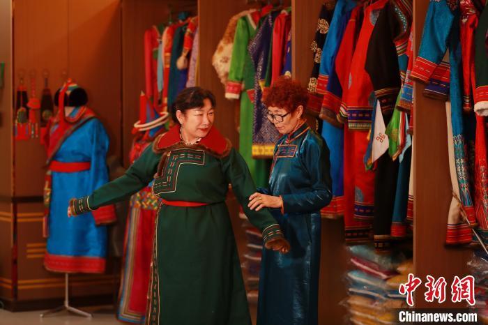 图为娜仁其其格正在为游客量体裁衣　陈坤　摄